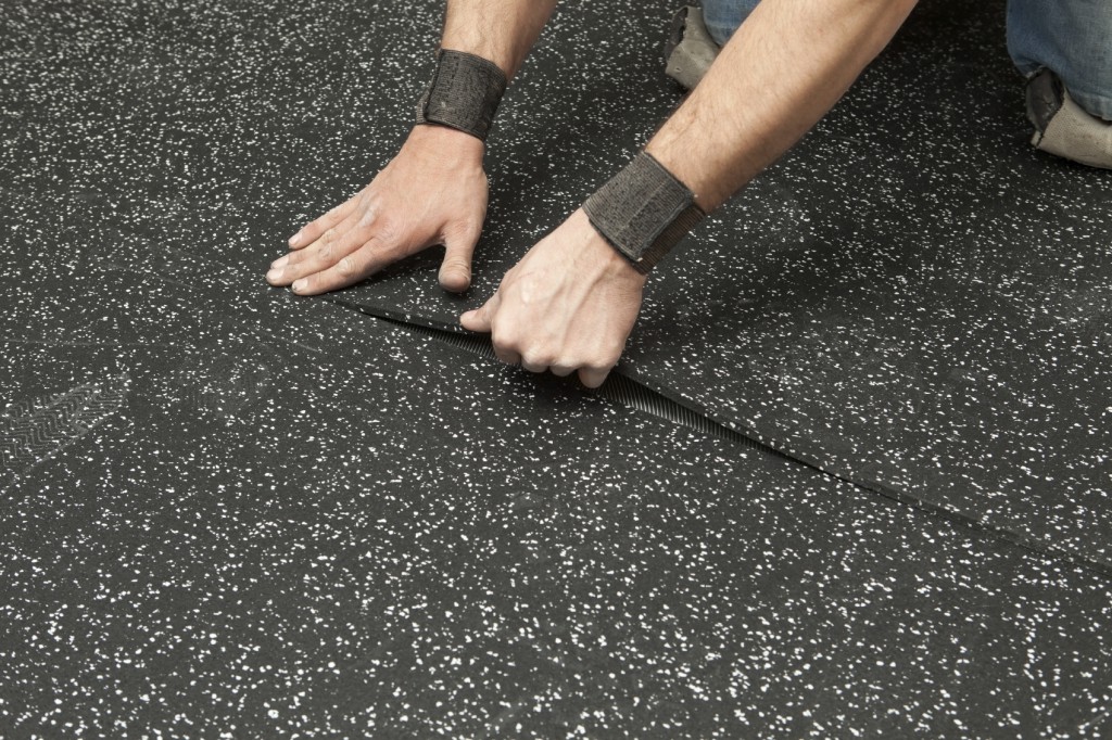 person installing rubber gym flooring